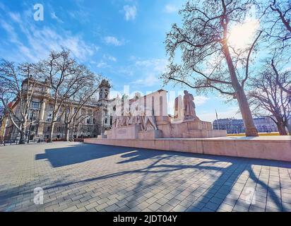 The sunny Lajos Kossuth Square with a view on complex stone Kossuth Memorial and building of Ethnographic Museum (Palace of Justice) in background, Bu Stock Photo