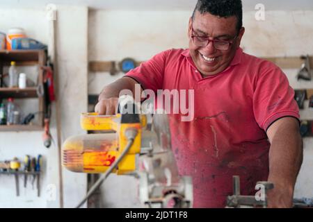Latin Carpenter using a circular saw in the workshop Stock Photo