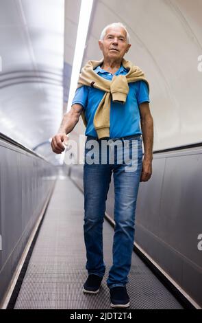 Elderly man going down to subway station Stock Photo