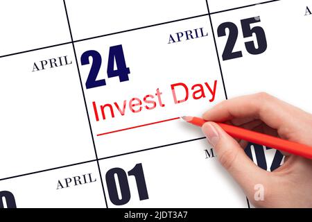24th day of April. Hand drawing red line and writing the text Invest Day on calendar date April 24. Business and financial concept. Spring month, day Stock Photo