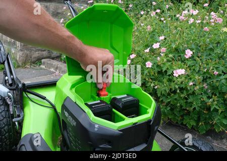 The red key plug on a Greenworks battery operated lawnmower is a safety feature. Stock Photo