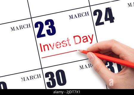 23rd day of March. Hand drawing red line and writing the text Invest Day on calendar date March 23. Business and financial concept. Spring month, day Stock Photo