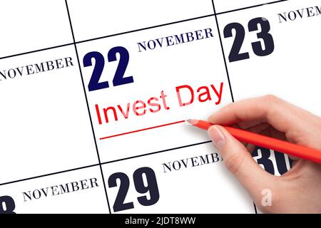 22nd day of November. Hand drawing red line and writing the text Invest Day on calendar date November 22. Business and financial concept. Autumn month Stock Photo