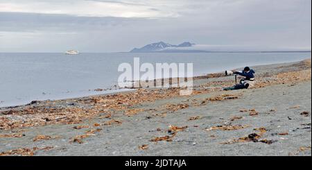 Nature photographer in action at Poolepynten, Prins Karls Forland, Svlabrad. Stock Photo