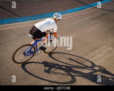 Athletic woman with prosthetic arm riding bicycle Stock Photo