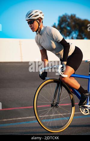 Athletic woman with prosthetic arm riding bicycle Stock Photo