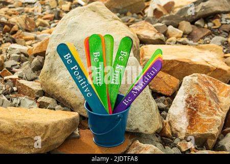 Motivational quote written on a colorful wooden sticks inside of a blue bucket - Be positive, be true, be kind, be mindful. Stock Photo