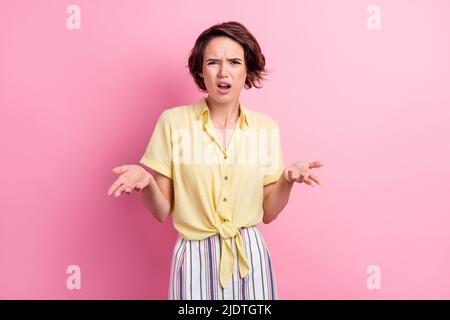 Photo of angry young brunette lady wear yellow t-shirt isolated on pink color background Stock Photo