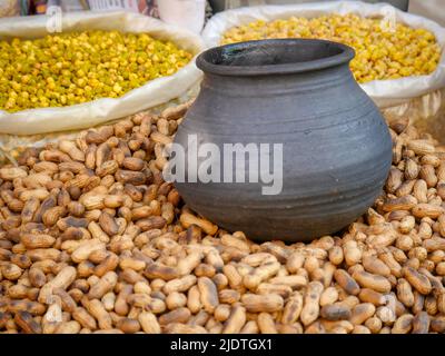 Heap of roasting raw peanuts, Smoke coming out of pot with peanuts below. peanut also known as the groundnut, goober, pindar or monkey nut. Stock Photo