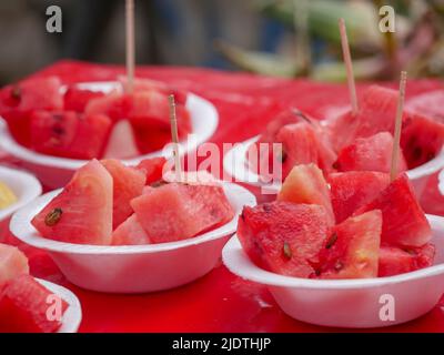 Close up sliced red watermelon cubes pieces in plastic cup Stock Photo