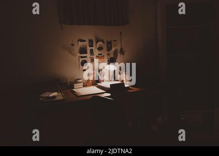 sad messy desk with spotlight at night Stock Photo