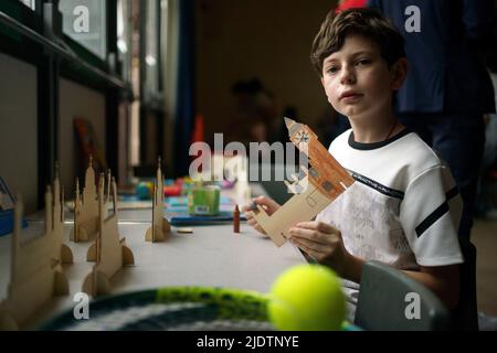 A young Ukrainian refugee draws the Houses of Parliament as Ukrainian families who have recently settled in the south London borough of Merton attend a Wimbledon themed afternoon tea, hosted by The Wimbledon Foundation, at New Horizons Centre, in Pollards Hill, south London. The guests, who have been supported by the Polish Family Association since their arrival, have all been surprised with a gift of tickets to The Championships donated by the All England Club. Picture date: Thursday June 23, 2022. Stock Photo