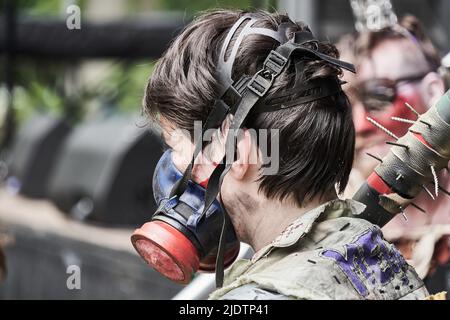Pattensen, Germany, June 4, 2022: Young man with tattered clothes protects himself from toxic gases with a gas mask at a fantasy festival in Germany Stock Photo