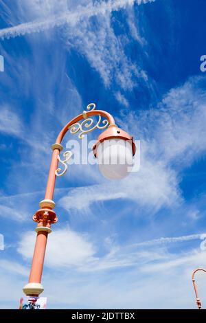 Ornate, pink victorian lampposts against a deep blue sky Stock Photo