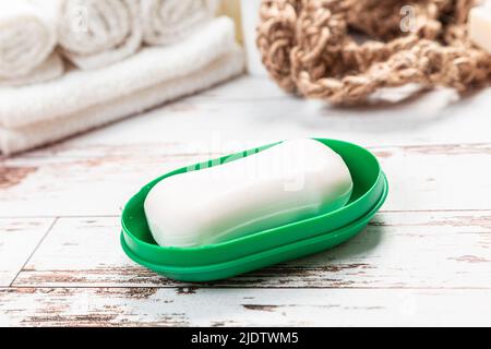 new soap on a green soap dish, on a white wooden background. hygiene concept Stock Photo