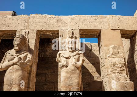 Statues of ancient Egyptian pharaohs and gods. Various hieroglyphs on ...
