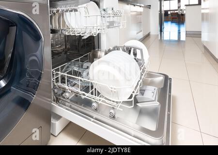Open dishwasher with clean dishes in a modern kitchen Stock Photo