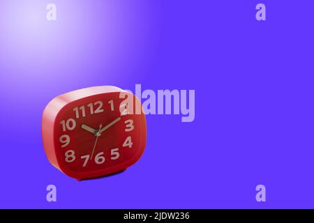 Red alarm clock isolated on blue background. Stock Photo