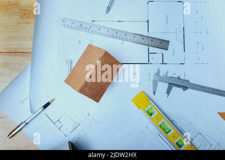 Business, architecture, building and construction concept - Top view of architects house model with measurement tool and blueprints on architect desk Stock Photo