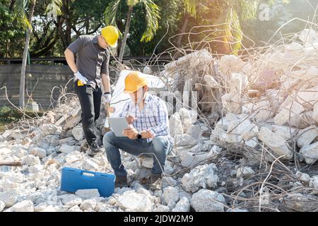 Demolition control supervisor and contractor using tablet to planning on demolish building. Stock Photo