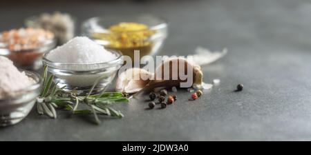Different types of salt and culinary spices in glass plates on a dark background Stock Photo