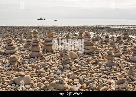 Stone piles or cairns on pebble beach, Lindisfarne (Holy Island) Northumberland, England. Stock Photo