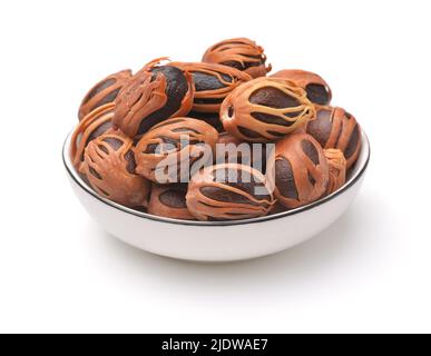 Whole nutmegs with mace in ceramic bowl  isolated on white Stock Photo