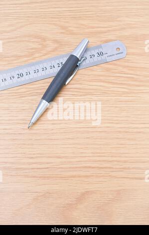 metal decimal ruler and pencil on a wooden desk Stock Photo