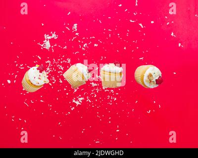 Small muffins with cream and fresh raspberries in frozen flight on a bright pink background. Sweet food, holiday treat, light summer dessert. Advertis Stock Photo