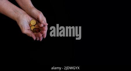 woman's hands with money on a black background, feed from above, copy paste Stock Photo