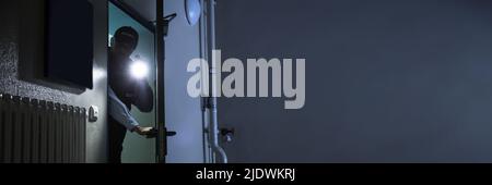Male Security Guard Searching With Flashlight At Industry Stock Photo