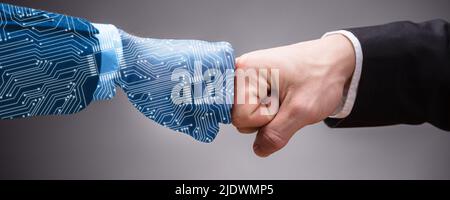 Close-up Of Digital Generated Human Hand And Businessman Making Fist Bump On Grey Background Stock Photo