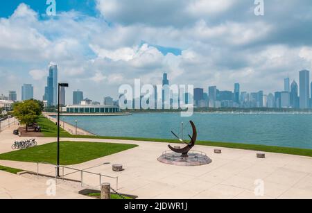 Chicago skyline and Sundial sculpture,  is named is Man Enters the Cosmos, located on the plaza of Adler Planetarium, Chicago, Illinois USA. Stock Photo