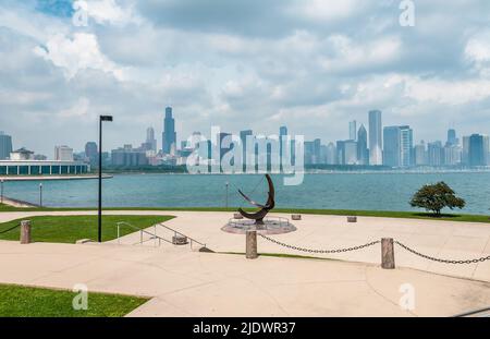 Chicago skyline and Sundial sculpture,  is named is Man Enters the Cosmos, located on the plaza of Adler Planetarium, Chicago, Illinois USA. Stock Photo