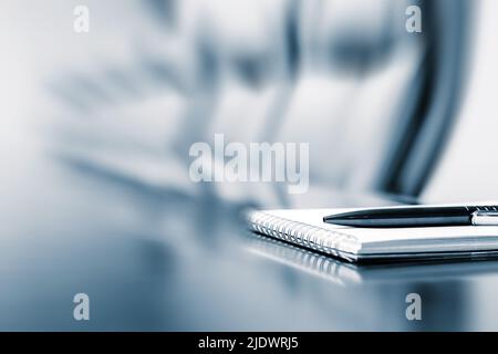 Closeup of notepad kept on table in empty room with motion blur effect Stock Photo