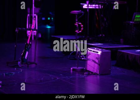 Fender Amplifier and guitar set up on stage under pruple stage lighting Stock Photo