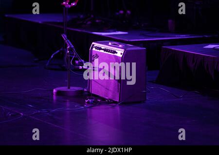 Fender Amplifier and guitar set up on stage under pruple stage lighting Stock Photo