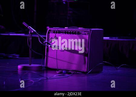 Fender Amplifier and guitar set up on stage under pruple stage lighting Stock Photo