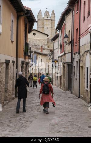 Spain, Castilla y Leon, Walking through the Streets of Castrojeriz on the Camino de Santiago, Church of San Juan in background. Stock Photo