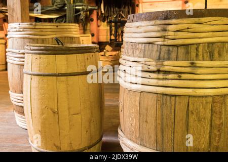 Old antique wooden barrels in lined up in a warehouse Stock Photo