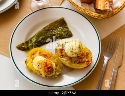 Twice baked potatoes stuffed with meat, jam, cheese and egg Stock Photo