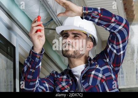 service man installing window with screwdriver Stock Photo