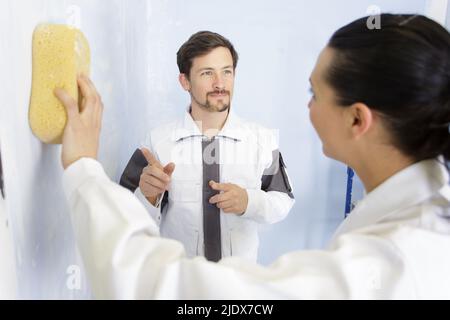 female decorator using sponge on interior wall Stock Photo