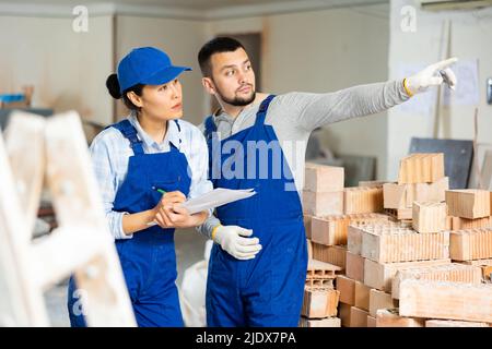 Woman and man repairers talking about documentation Stock Photo