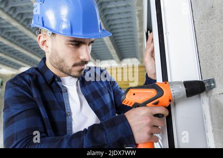young male worker using cordless screwdriver Stock Photo