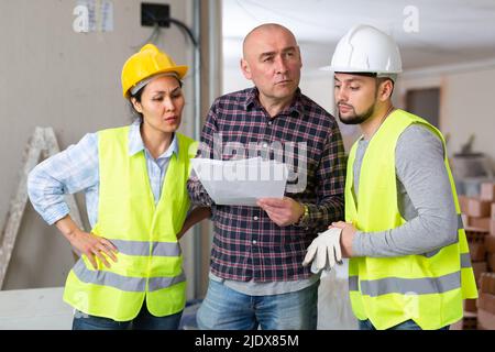 Architect and engineers discussing work in construction site Stock Photo