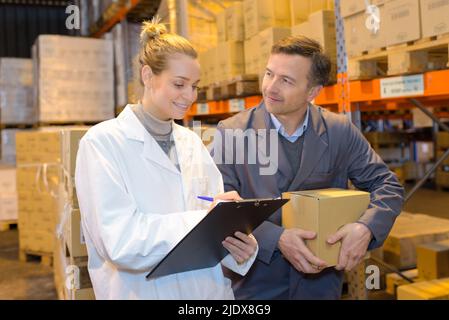 manager standing in front warehouse worker in warehouse Stock Photo