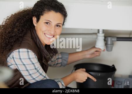 portrait of a female plumber fixing pipes Stock Photo
