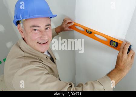 man measures the wall with a level Stock Photo