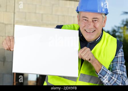 happy builder holding a white board Stock Photo